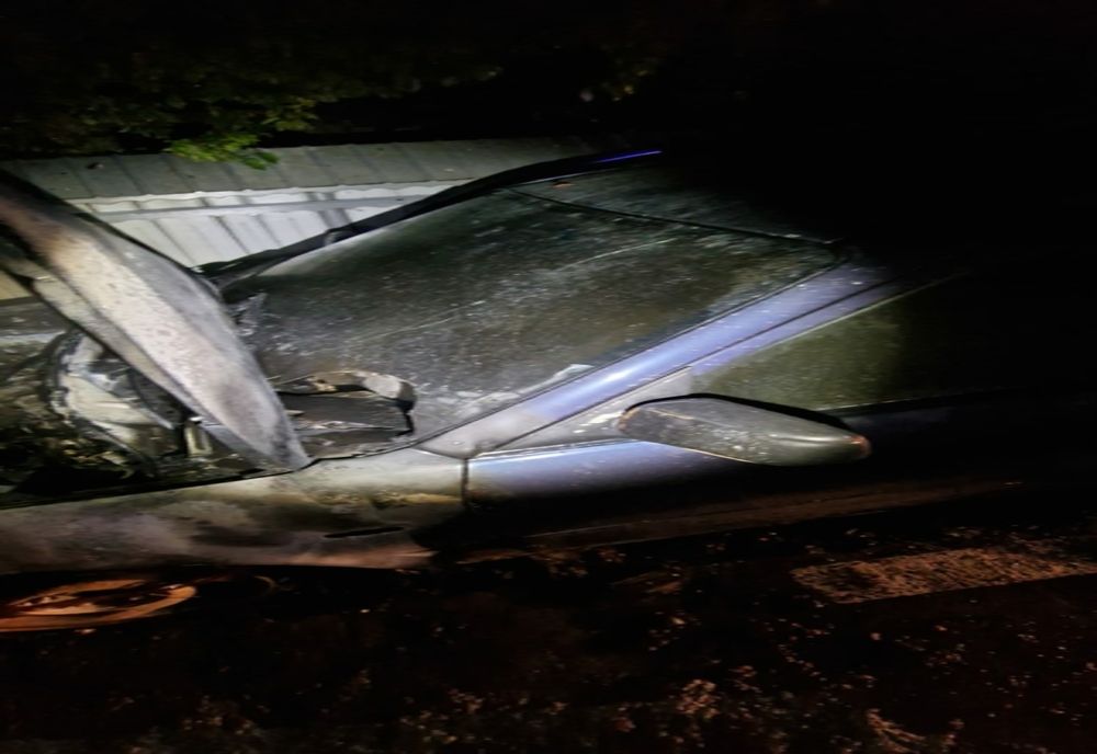 O mașină a luat foc lângă gardul unde era parcată